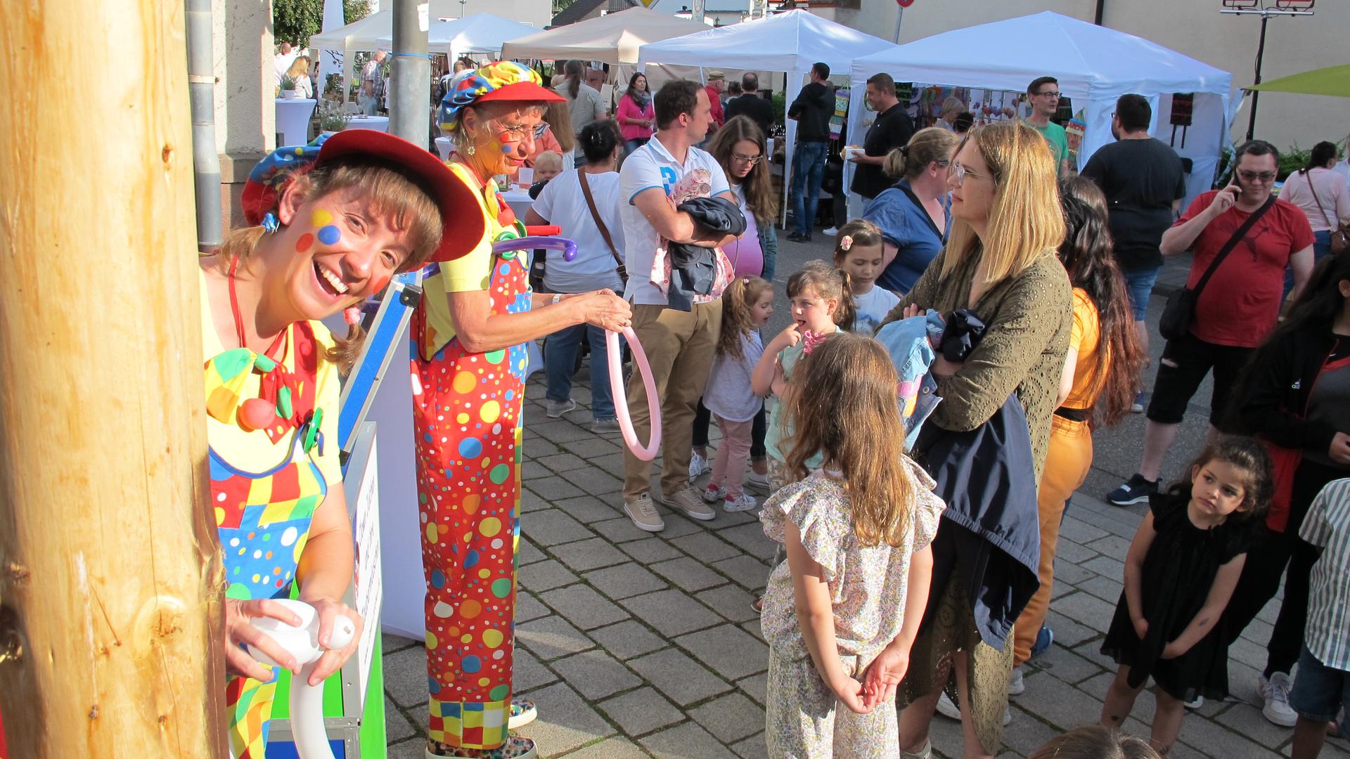 Bienchen und Clown Julchen (von links) knoten für Kinder Luftballons zu lustigen Figuren.