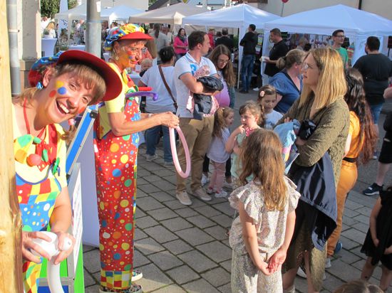 Bienchen und Clown Julchen (von links) knoten für Kinder Luftballons zu lustigen Figuren.