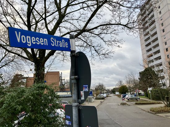 Schild der Vogesen Straße. Im Hintergrund ist die zugehörige Straße zu sehen.