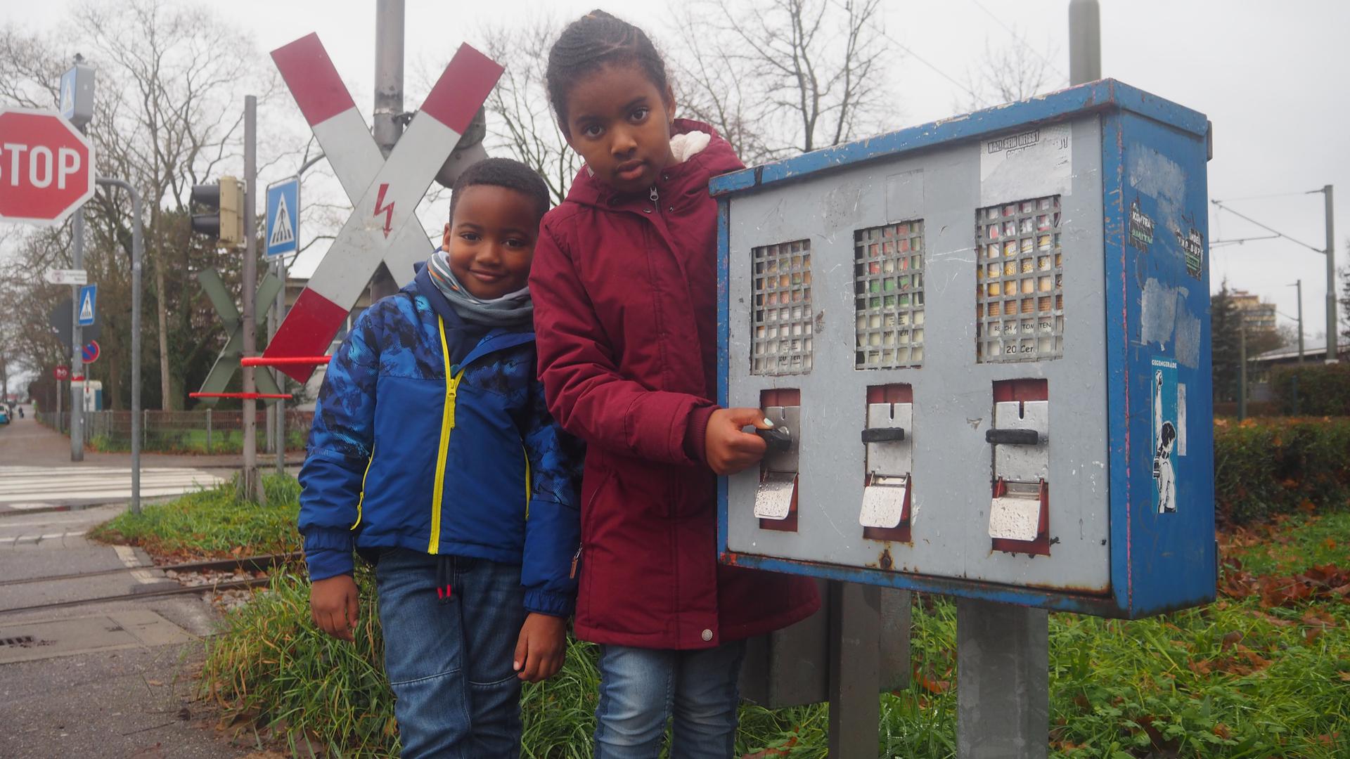 Wird noch regelmäßig befüllt: Naima (9) und ihr Bruder Bello (6) freuen sich darüber, dass der alte Kaugummiautomat vor dem Jugendzentrum Specht funktioniert und für 20 Cent eine gelbe Kugel herauskommt.