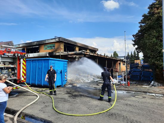 Es rauchte auch noch am Tag danach: Ein Feuerwehrmann löscht am Freitagnachmittag gegen 14 Uhr Glutnester, die in den verkohlten Überresten des Brandes in der Lagerhalle im Ettlinger Industriegebiet entstanden sind.