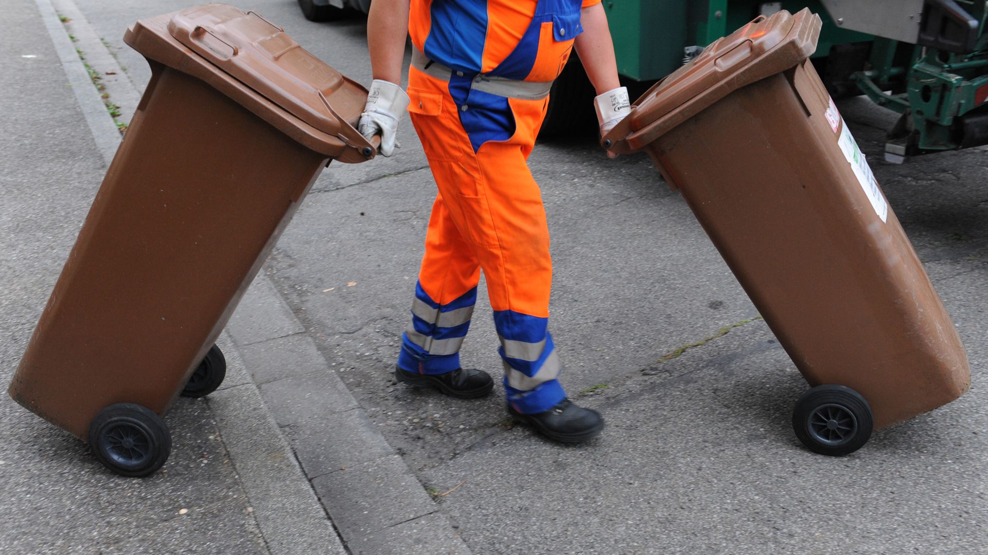 ARCHIV - Ein Mitarbeiter der Abfallwirtschaft und Stadtreinigung schiebt am 31.07.2012 in Freiburg (Baden-Württemberg) eine braune Tonne mit Biomüll zum Müllwagen.