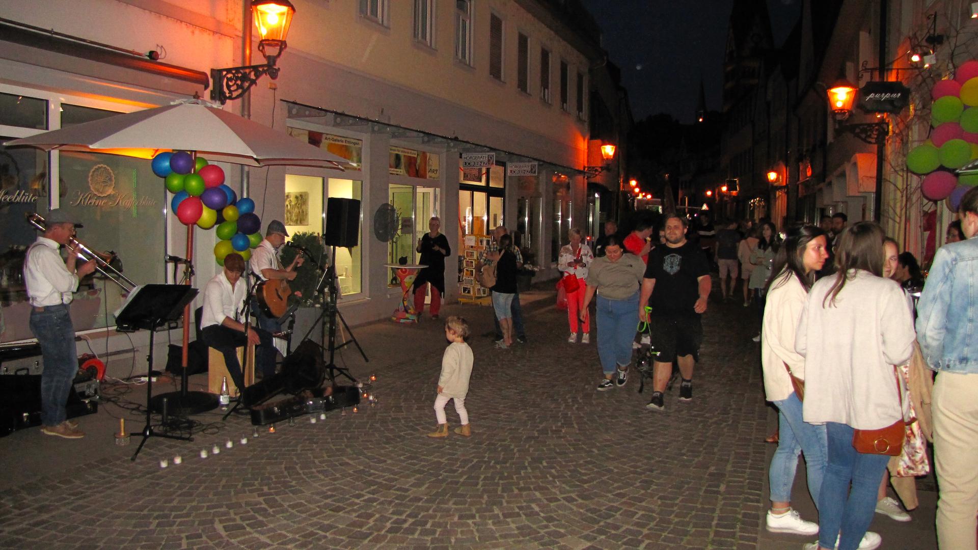 Eine Musikgruppe sorgt für Leben in der Kronenstraße und ein Mädchen tanzt zu ihrer Musik.