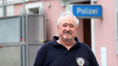 Mann vor einem Polizeirevierschild