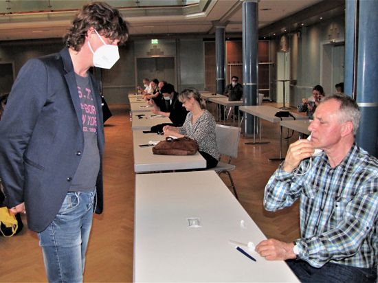 Der Mediziner Lutz Zöller beobachtet genau, ob Werner Löffler das Wattestäbchen korrekt anwendet.
