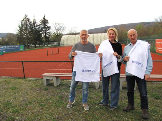 Drei personen stehen mit weißen Handtücher vor einem Sportplatz 