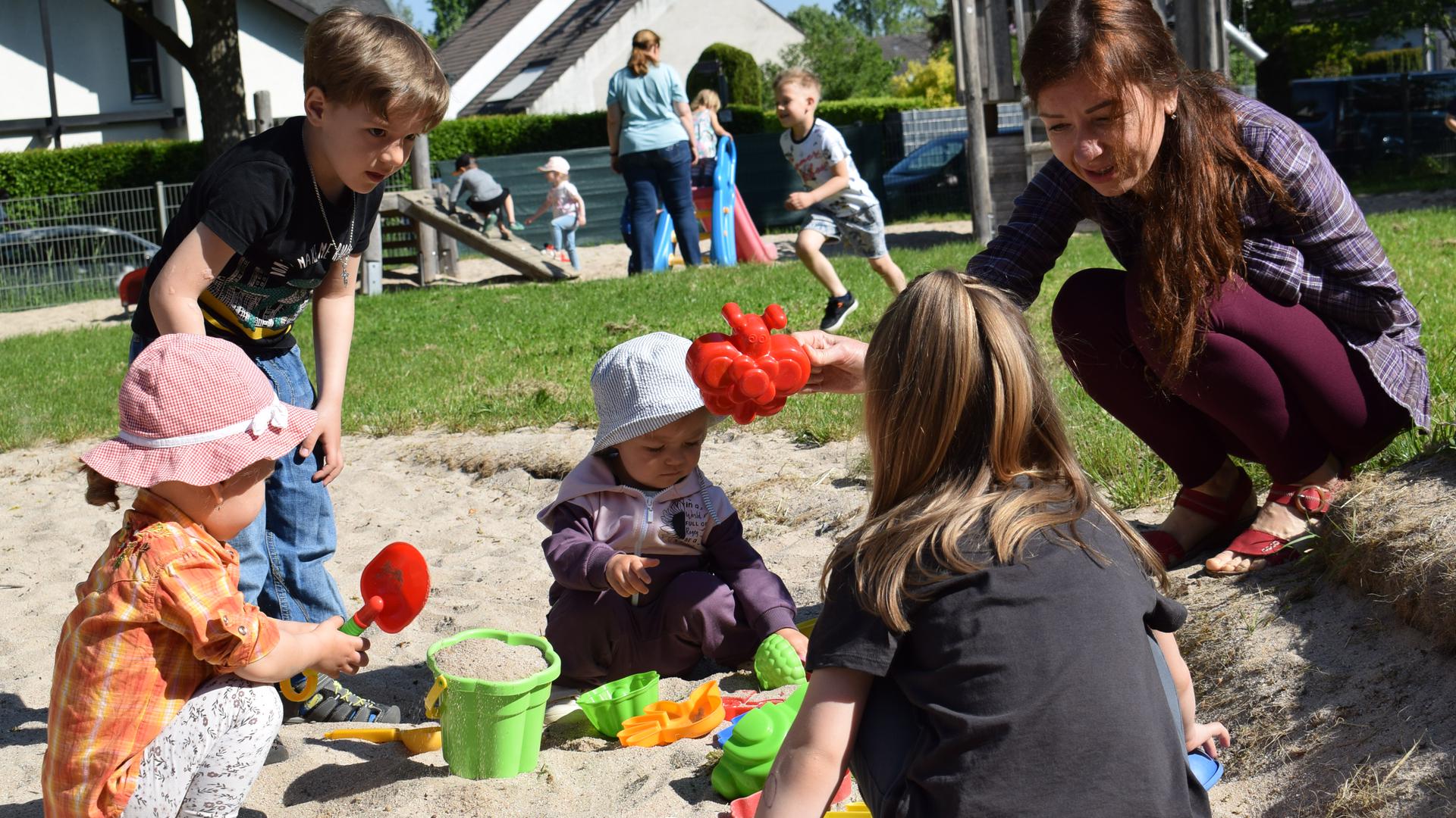 Erzieherin Olga Seidel beschäftigt sich mit ukrainischen Kindern auf dem Spielplatz des Container-Kindergartens im Ettlinger Horbachpark.
