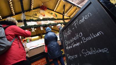 Eine Werbetafel vor dem  Pizzastand auf dem Ettlinger Sternlesmarkt zeigt vegetarische Angebote: Knobi-Fladen, Bruschetta mit frischen Tomaten und Basilikum oder Peperoni und Schafskäse.