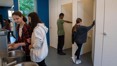 Jungen und Mädchen gehen in eine Unisextoilette an der Sägefeldschule im Ortsteil Wiblingen. Bei der Sanierung der Toilettenanlage an der Werkrealschule wurde die Geschlechtertrennung aufgehoben. +++ dpa-Bildfunk +++