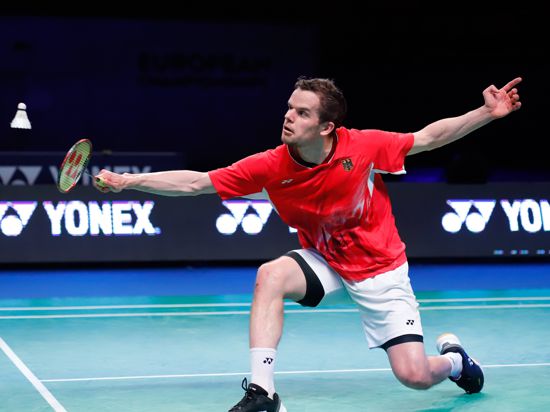 Badmintonspieler Fabian Roth schlägt den Federball über das Netz.