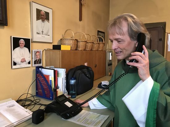 Pfarrer Matthias Weingärtner in der Sakristei der katholischen Kirche St. Bernhard in Bad Herrenalb. Er begrüßt und verabschiedet persönlich die Teilnehmer des Telefongottesdienstes.