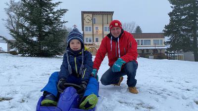 Fürs Rodeln reicht’s schon: Niklas aus Durmersheim testet mit seinem Papa den Schnee vor dem Kindergarten.