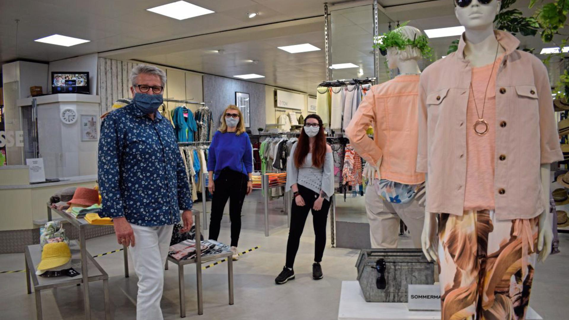 Mit Maske und Mindestabstand begrüßen Rainer Behringer (links) und seine Mitarbeiterinnen die Kunden im Modehaus Streit.