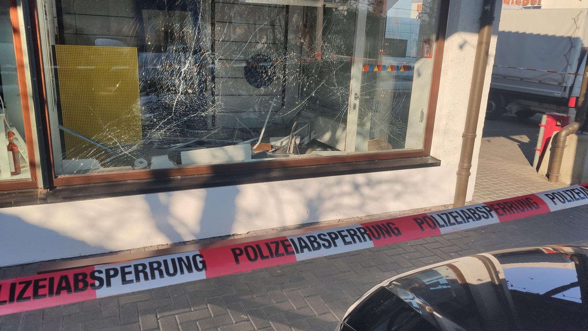 Hinter einem Absperrband der Polizei ist die zersplitterte Gasscheibe der Sparda-Bank-Selbstbedienungsfiliale in Karlsbad-Langensteinbach zu sehen.