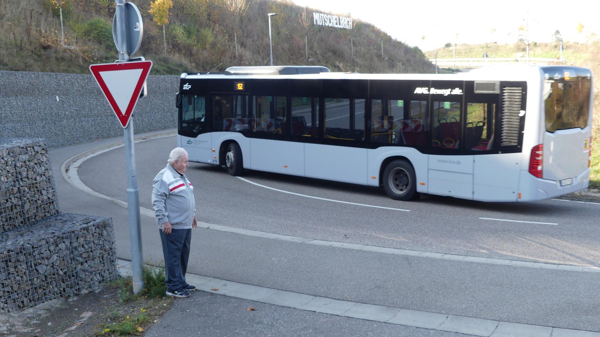 Ein Linienbus fährt durch die Spitzkehre hoch zur Omega-Brücke. Links steht Erwin Balzer.