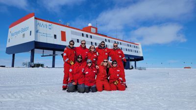 Das Überwinterungs-Team 2022 steht vor der Neumayer-Station in der Antarktis.