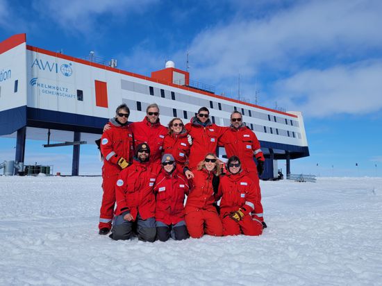 Das Überwinterungs-Team 2022 steht vor der Neumayer-Station in der Antarktis.