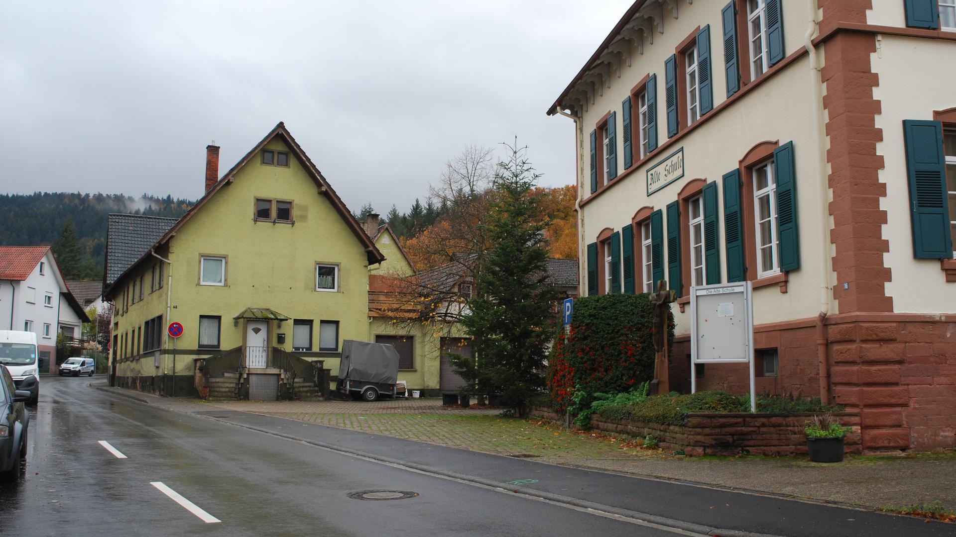 Altes Gasthaus „Adler“ mit gelber Fassade neben alter Schule.