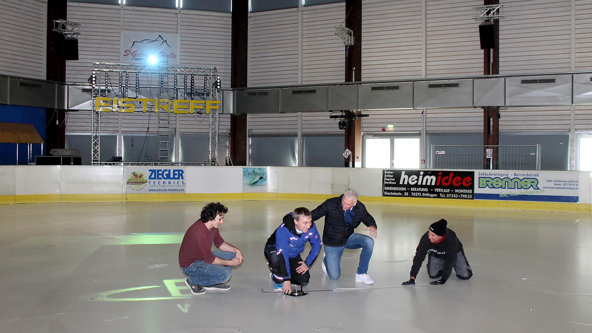 Millimeterarbeit: Die Lage des LED-Lichtes im Eis muss genau ausgemessen werden. Das klappt im Team, hier mit Michael Müller, Alexander Schroth, Manfred Wolf und Klaus Scharli (von links).