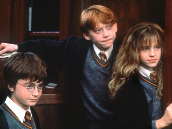 Voller Erwartung stehen die Zauberlehrlinge Harry Potter (Daniel Radcliffe, l.), Ron Weasley (Rupert Grint) und Hermine Granger (Emma Watson) im Kinofilm "Harry Potter und der Stein der Weisen" an der Tür zur Hogwarts-Schule für Zauberkunst.