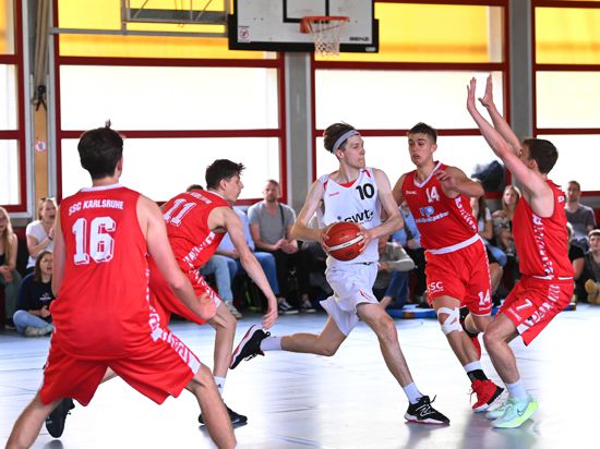 Ein Basketballspieler zieht zum Korb, vier Gegner können den Korbleger nicht verhindern.