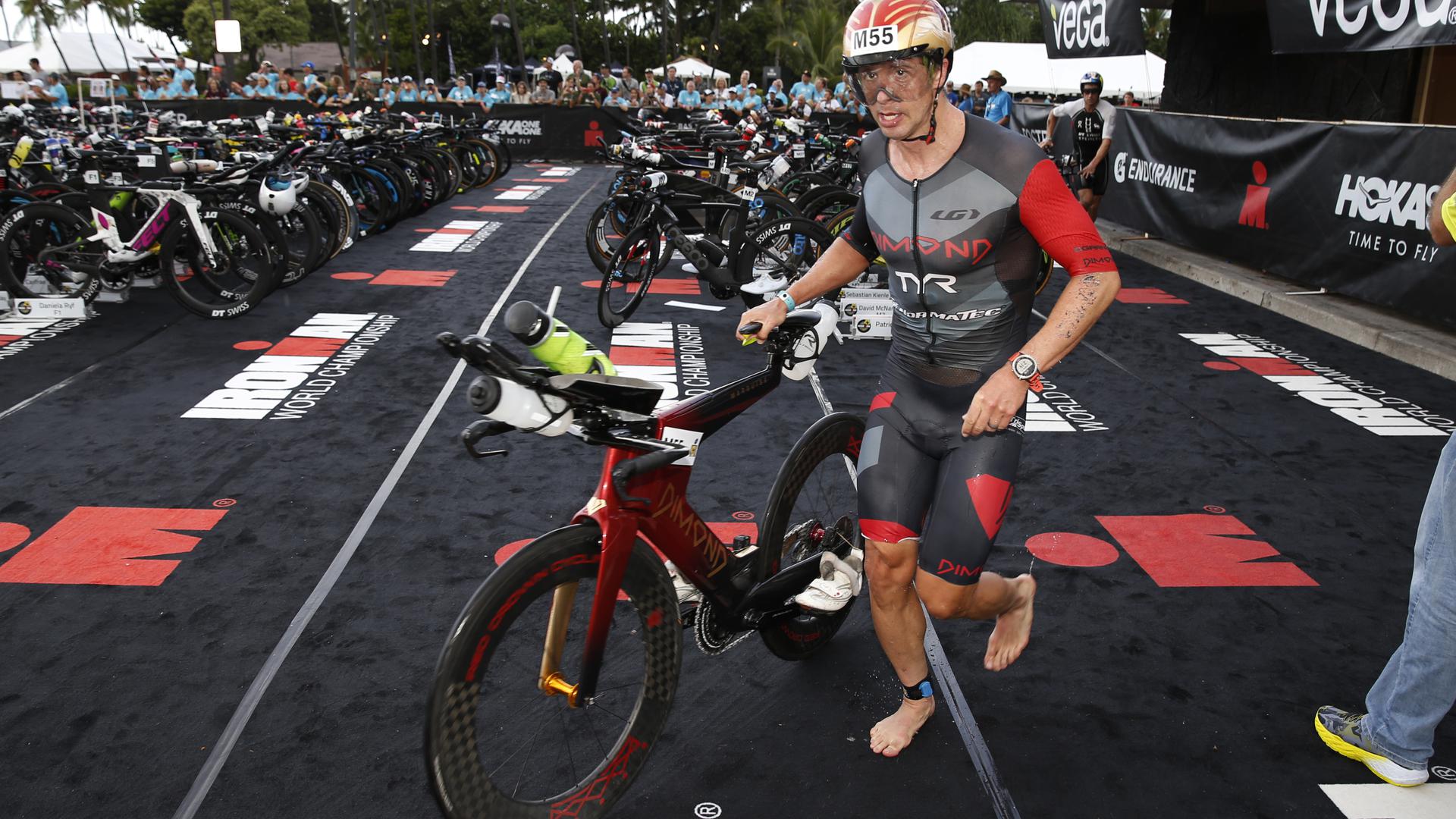 Ironman-WM auf Hawaii: Sebastian Kienle ist barfuß, während er sein Fahrrad schiebt.