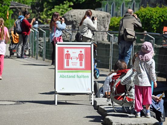 Besucher des Karlsruher Zoos stehen an einem Gehege. Der Zoo muss wegen der Corona-Krise wieder schließen.