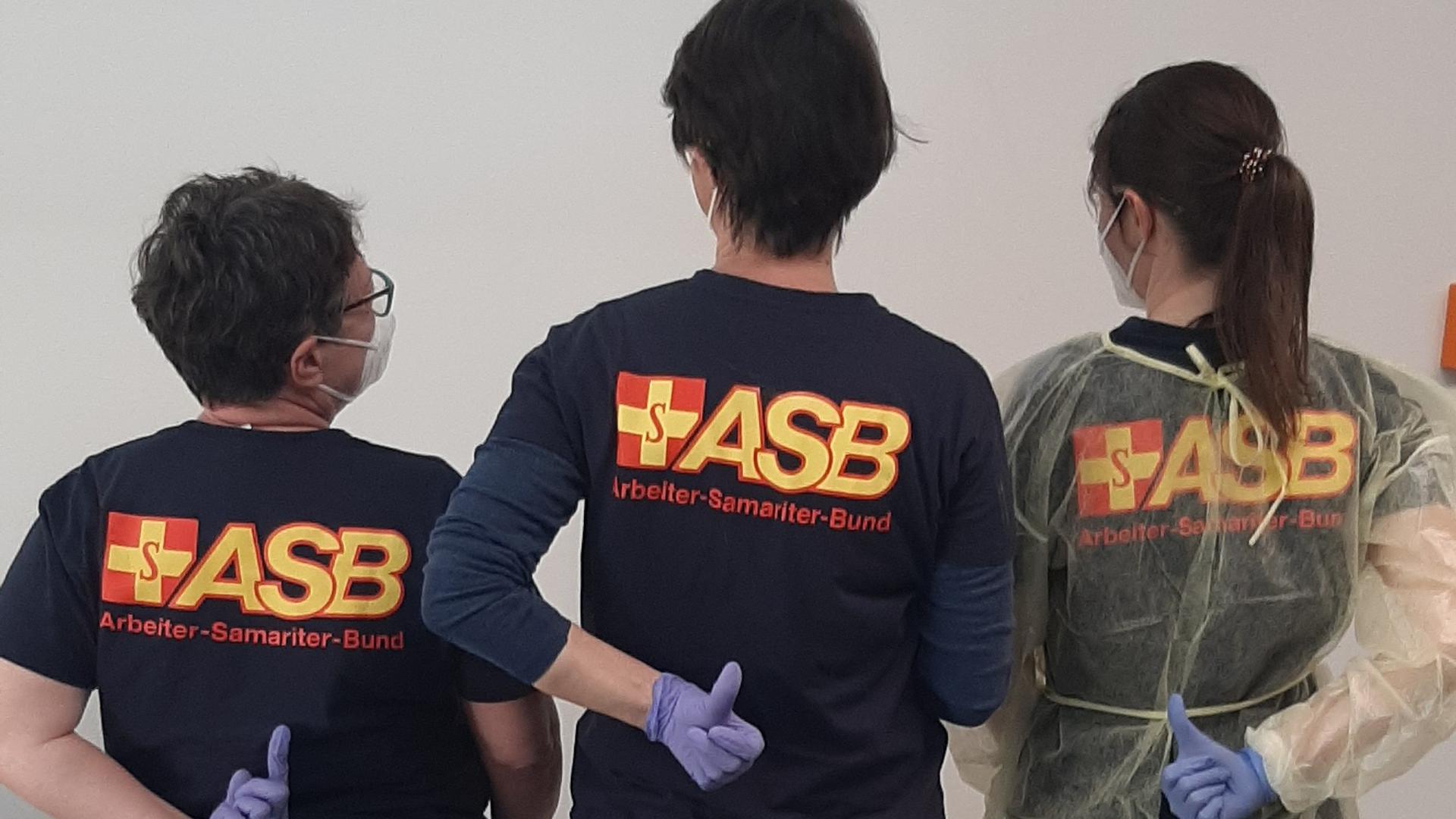 Drei Personen in T-Shirts des Arbeiter-Samariter-Bundes. 