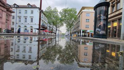 Fußgänger suchen sich einen Weg am Rand: Auf der Kaiserstraße stand nach dem gestrigen Gewitter das Wasser. 