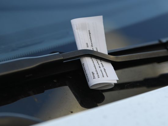 Ein Strafzettel klemmt an einem Auto in der Frankfurter Innenstadt an einem Scheibenwischer. (zu dpa «Klingelnde Kassen: Verkehrssünder sorgen für mehr Knöllchen-Einnahmen») +++ dpa-Bildfunk +++