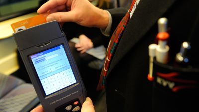 Ein Kontrolleur des Karlsruher Verkehrsverbunds (KVV) überprüft mit einem Handlesegerät die Fahrkarte eines Fahrgastes. 