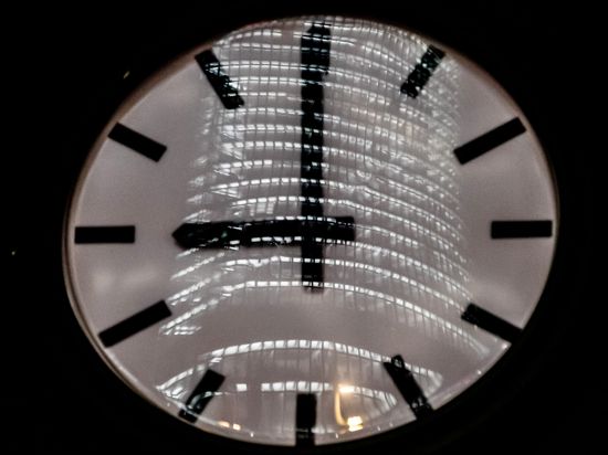 Die Uhr am Verkehrsturm am Potsdamer Platz zeigt 21:00 Uhr, wobei sich ein Bürogebäude darin spiegelt. +++ dpa-Bildfunk +++