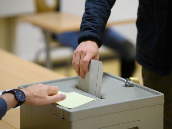 Ein Wähler wirft im Wahllokal seinen Stimmzettel in eine Wahlurne.