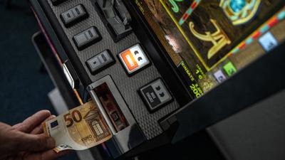 Ein Geldschein wird in einen Fun-Game-Automat geschoben.