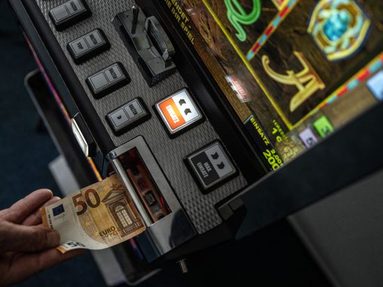Ein Geldschein wird in einen Fun-Game-Automat geschoben.