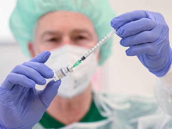 Ein Mitarbeiter des Klinikums Stuttgart bereitet in einer Impfstation eine Spritze für eine Impfung gegen das Coronavirus vor. +++ dpa-Bildfunk +++