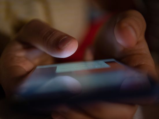 ILLUSTRATION - Ein Smartphone wird gehalten. Die Pandemie hat Forschern der Ruhr-Universität Bochum zufolge zu mehr «problematischer» Smartphone-Nutung geführt. (zu dpa «EU-Einigung auf Digital-Gesetz gegen Hass und Hetze») +++ dpa-Bildfunk +++