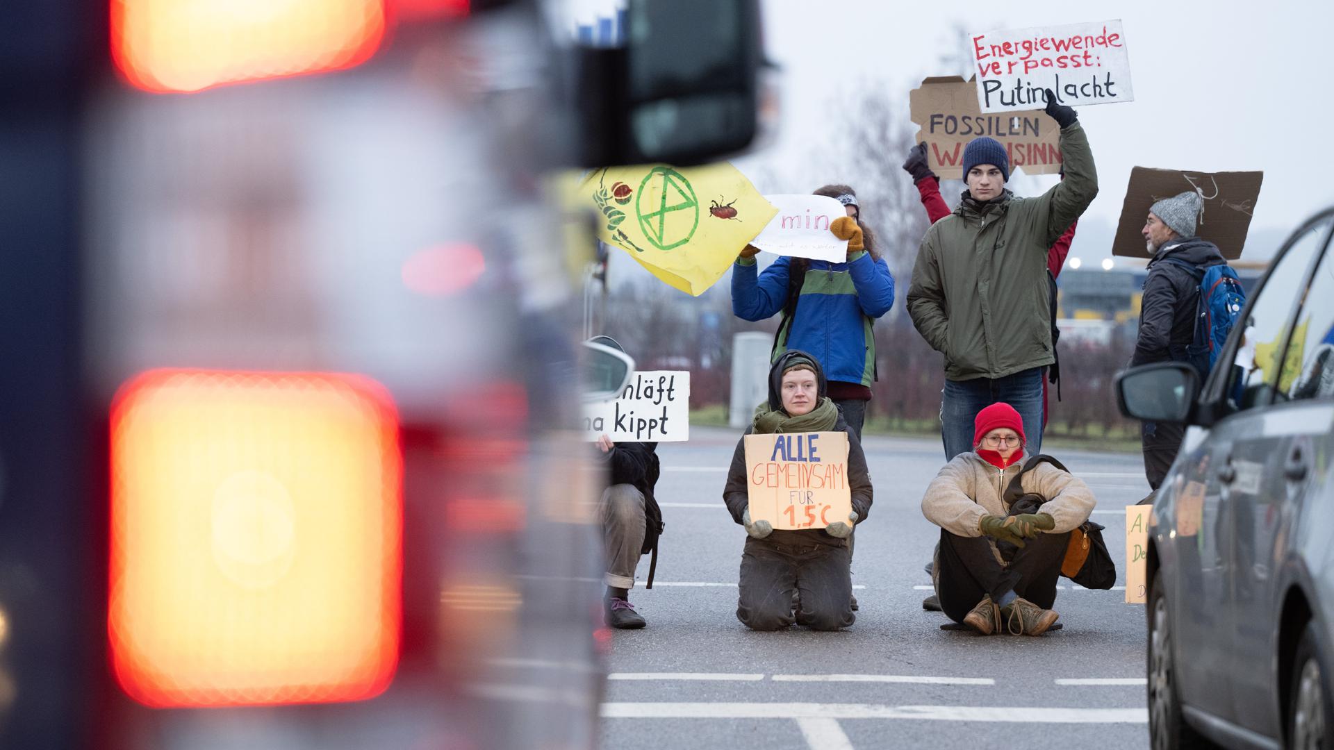 Umweltaktivisten sitzen und stehen während einer Demonstration auf der Fahrbahn auf der Washingtonstraße. Mitglieder der Klimaschutzgruppe Extinction Rebellion blockierten im Stadtteil Kaditz eine Kreuzung. 