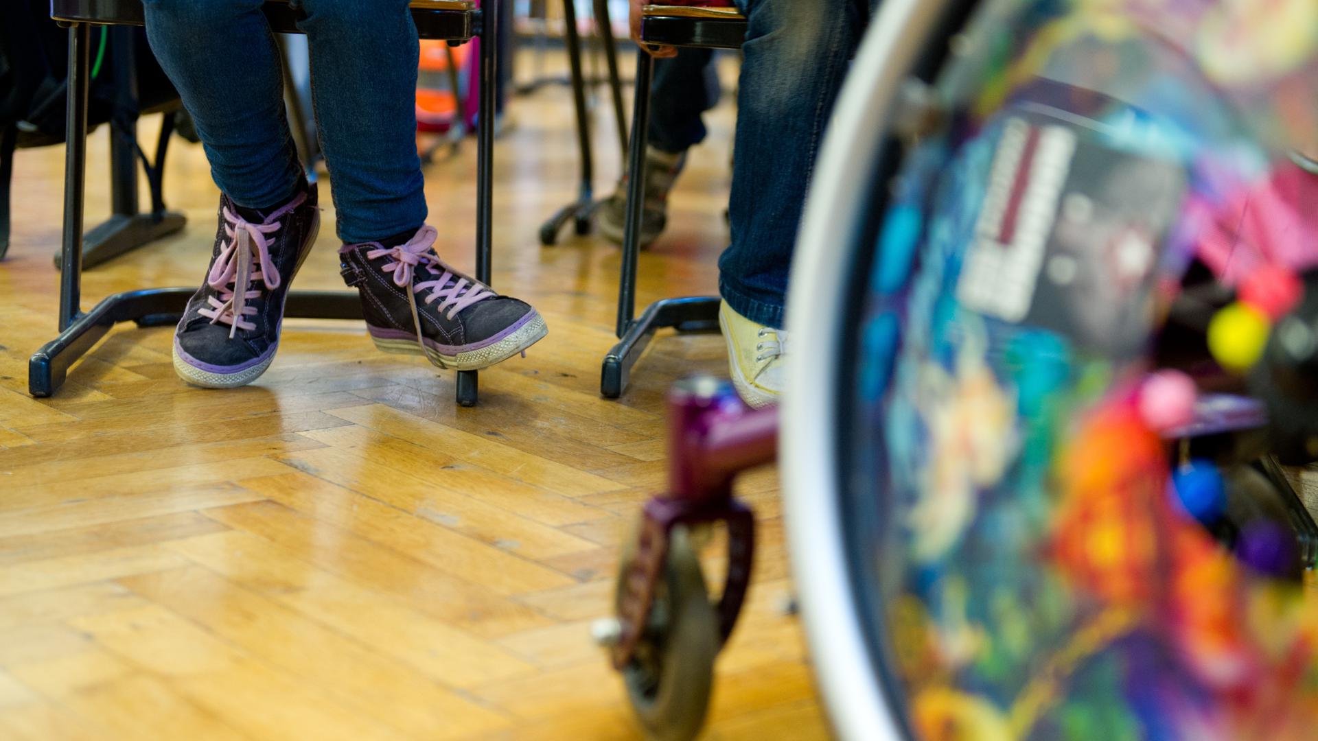 Ein Rollstuhl steht im Klassenzimmer einer Gemeinschaftsschule. 