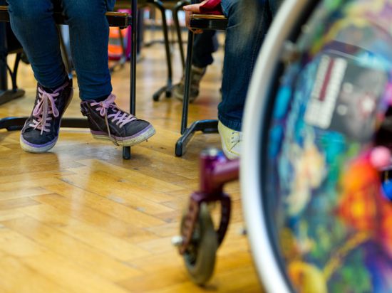 Ein Rollstuhl steht im Klassenzimmer einer Gemeinschaftsschule. 