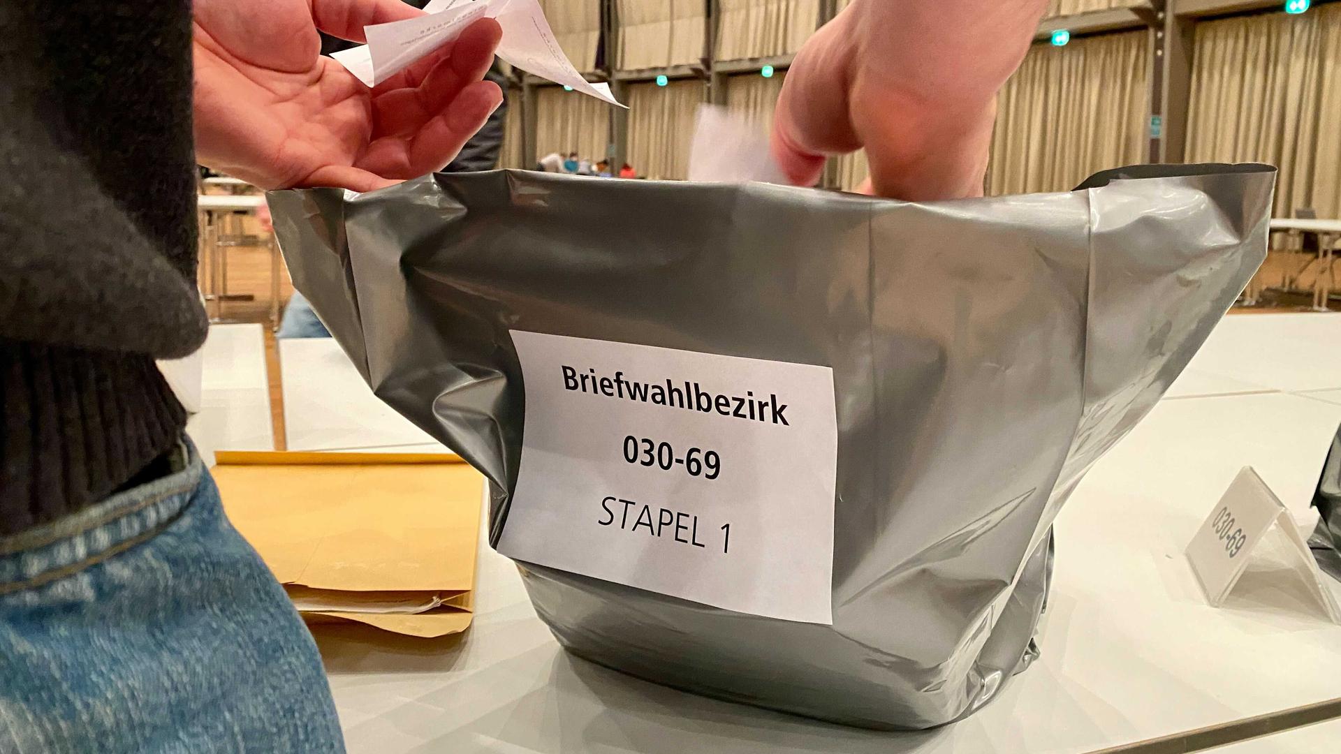 Ein Wahlhelfer versiegelt Stimmzettel der Briefwahl bei der OB-Wahl in Karlsruhe.