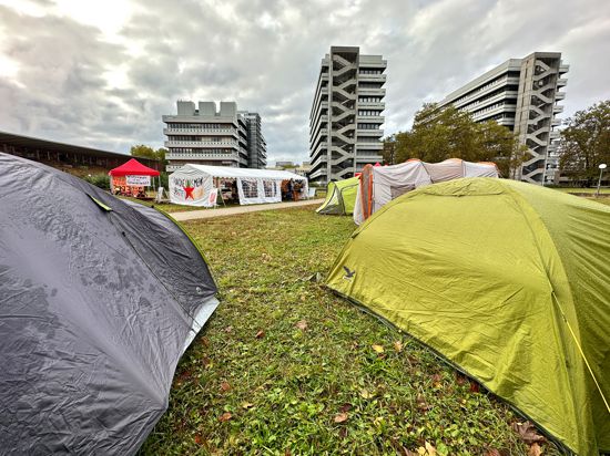 Das Protestcamp befindet sich auf einer Wiese auf dem Campus Süd des Karlsruher Instituts für Technologie (KIT), im Hintergrund sind Universitätsgebäude zu erkennen.
