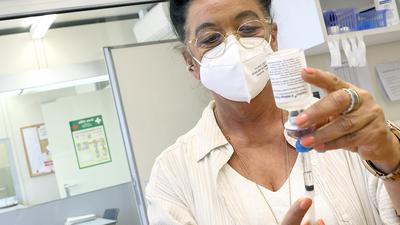 eine Frau zieht eine Spritze mit dem Substitutionsmittel Diamorphin ( künstliches Heroin) auf