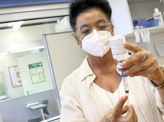 eine Frau zieht eine Spritze mit dem Substitutionsmittel Diamorphin ( künstliches Heroin) auf