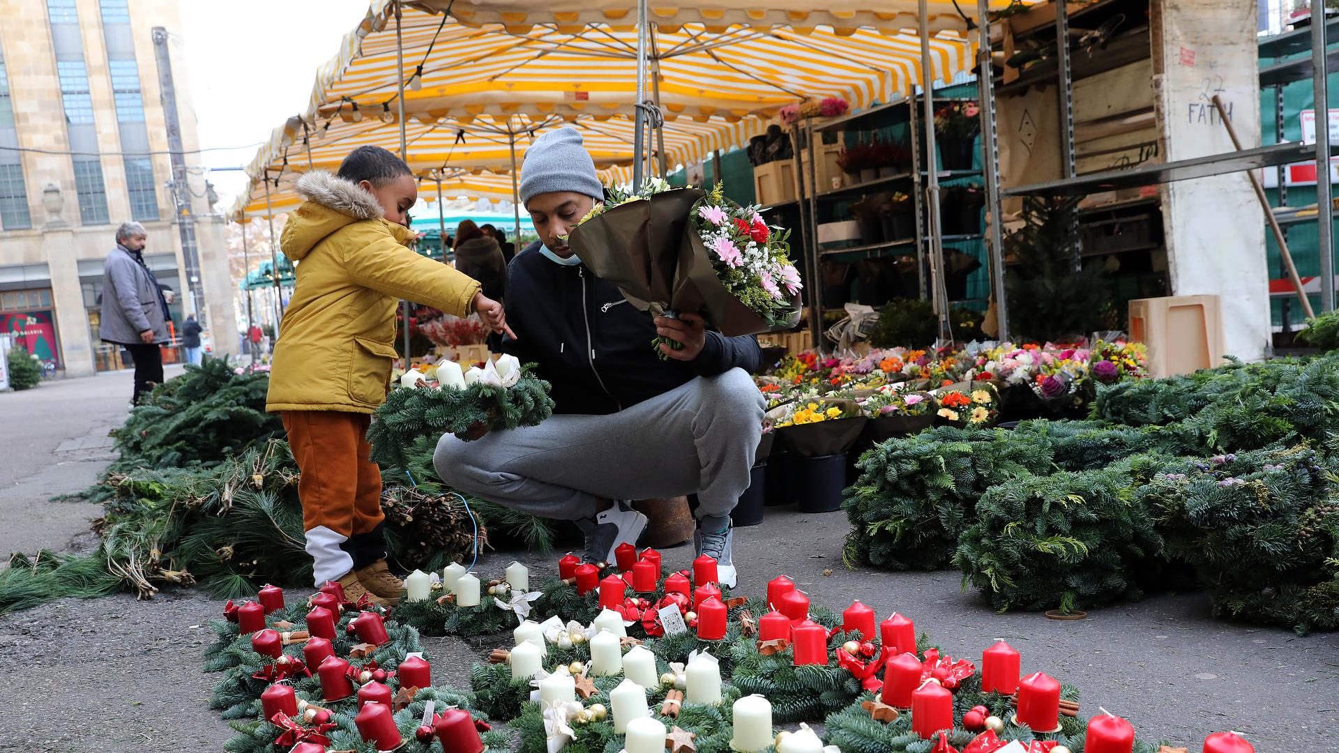Der Sohn trifft die Wahl: Am Karlsruher Blumenmarkt haben Kunden die Auswahl zwischen fertigen Adventskränzen mit verschiedenfarbigen Kerzen und ungeschmücktem Grün zum Selber-Dekorieren.