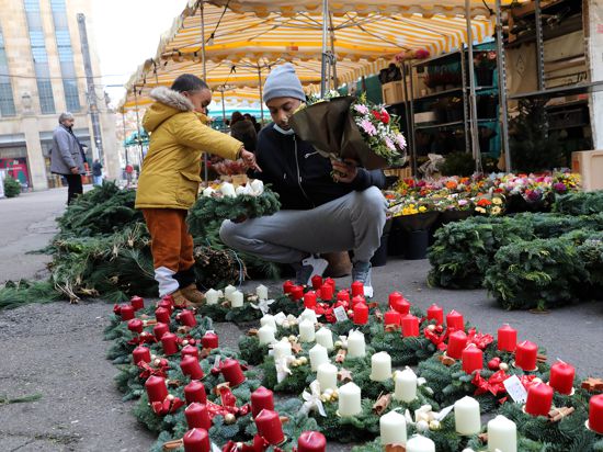 Der Sohn trifft die Wahl: Am Karlsruher Blumenmarkt haben Kunden die Auswahl zwischen fertigen Adventskränzen mit verschiedenfarbigen Kerzen und ungeschmücktem Grün zum Selber-Dekorieren.