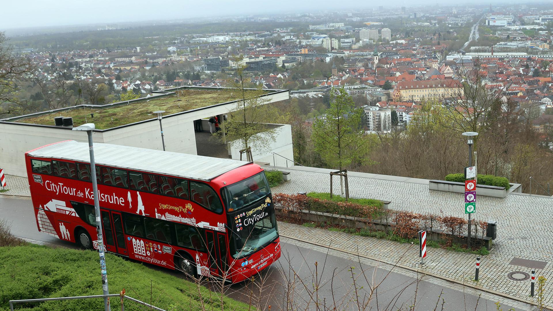 Roter Doppeldeckerbus fährt durch Karlsruhe.