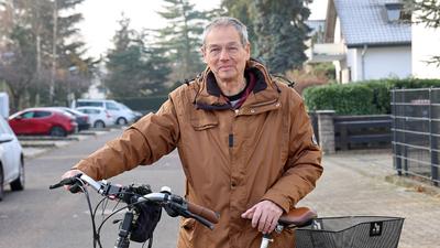 Am 13.12.2022 steht Karlsruhes weitradelnder Pfarrer Wolfram Engler mit seinem Fahrrad in seiner Wohnstraße in der Heidenstückersiedlung.