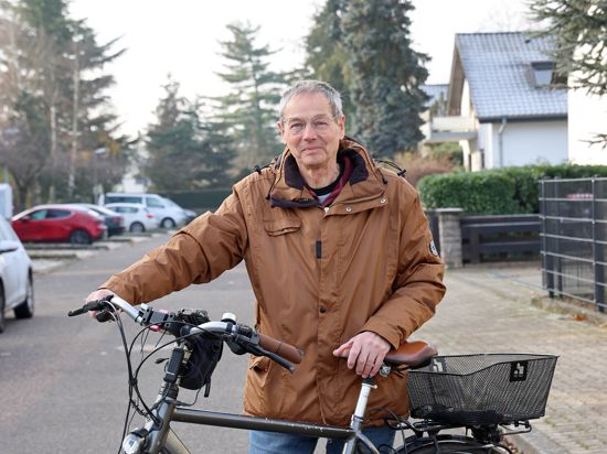 Am 13.12.2022 steht Karlsruhes weitradelnder Pfarrer Wolfram Engler mit seinem Fahrrad in seiner Wohnstraße in der Heidenstückersiedlung.