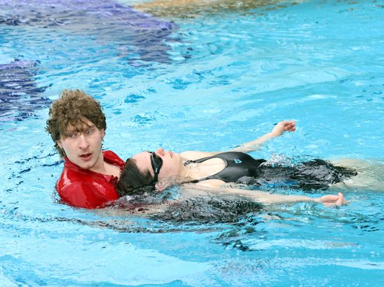 Europabad-Mitarbeiter Kevin Drobot zieht eine Frau aus dem Wasser.
